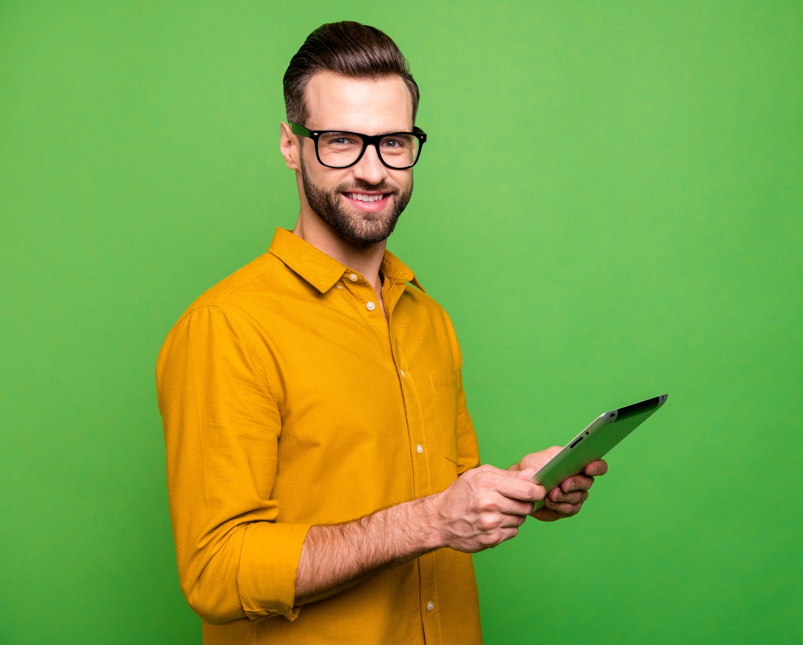 Un homme souriant consulte sa tablette numérique